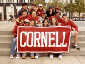Cornell students holding a red Cornell banner